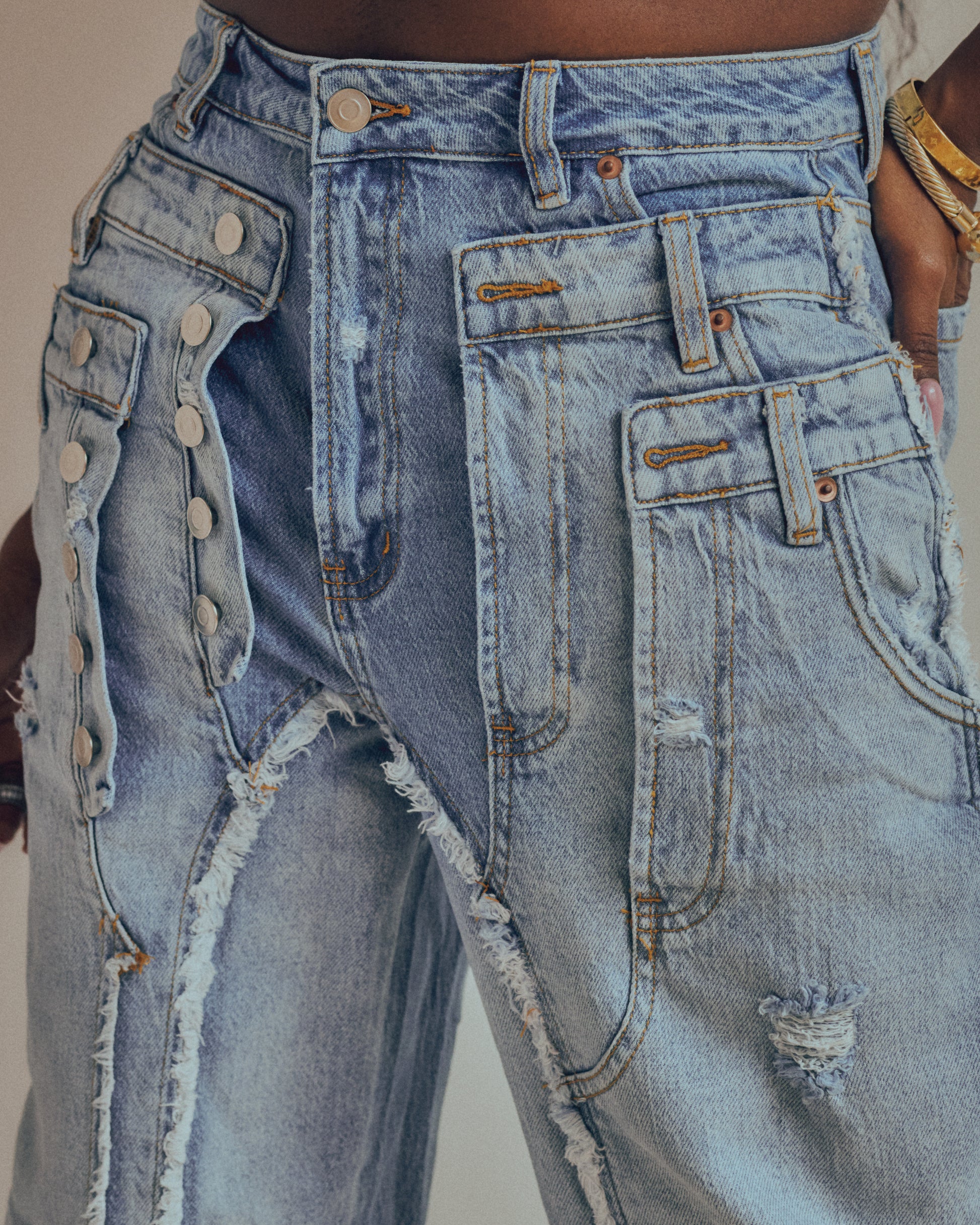 Close-up of a pair of distressed blue jeans with visible buttons and wear.