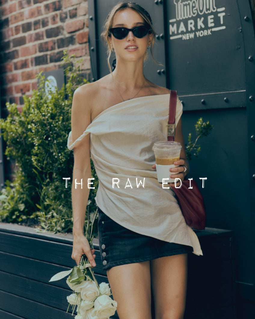Woman holding a coffee cup and flowers in front of a 'Time Out Market' building.